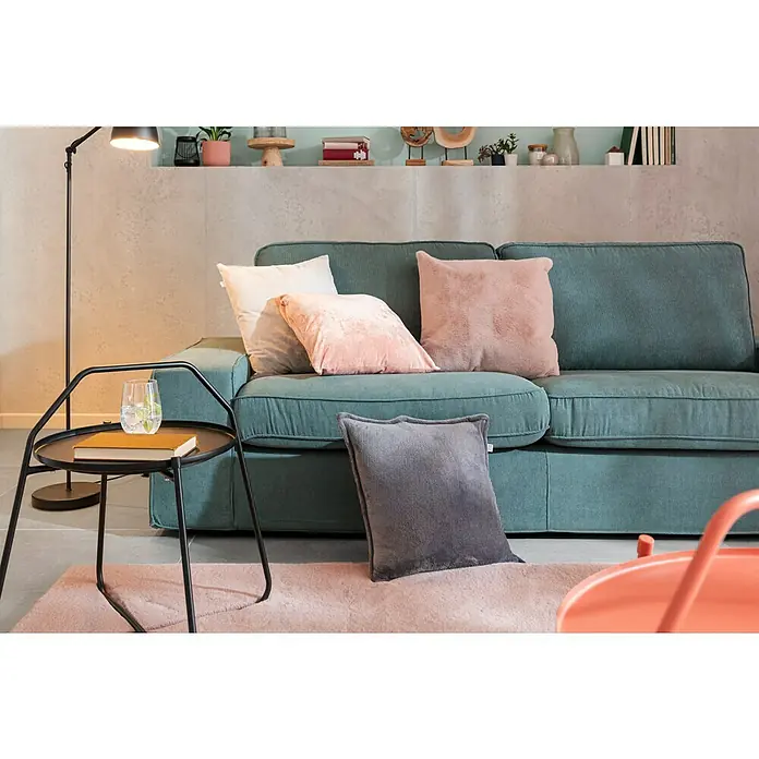 Fellteppich Happy - Rosa, 230 x 160 cm, 100 % Polyester (Flor) - Gemütliches Wohnzimmer-Arrangement mit mintgrünem Cord-Sofa, Zierkissen und Beistelltisch mit Buch und Getränk unter einer Stehlampe.