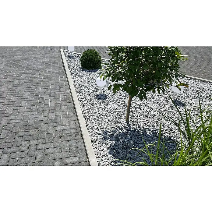 EHL Tiefbordstein - 100 x 20 x 8 cm, Anthrazit - Elegante Gartengestaltung mit grauem Pflaster und einem Kiesbeet, beleuchtet durch kugelförmige Gartenleuchten, die eine moderne Atmosphäre schaffen.