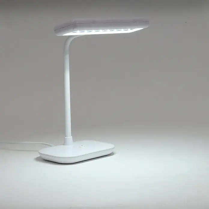 Briloner LED-Tischleuchte Daylight - 8 W, L x B x H: 23 x 12 x 44 cm, Weiß, Tageslichtweiß - Nahaufnahme einer modernen weißen LED-Tischleuchte, die auf einer weißen Oberfläche steht und ein helles, fokussiertes Licht ausstrahlt.