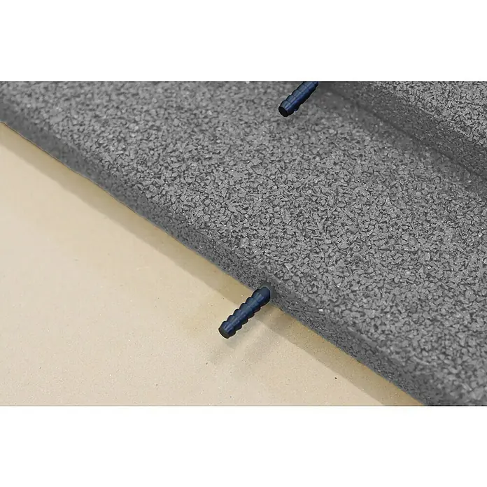Fallschutzmatte inkl. Steckverbindung - Grau, 50 x 50 x 3 cm - Nahaufnahme eines schwarzen Dachziegels mit zwei blauen Befestigungsstiften.