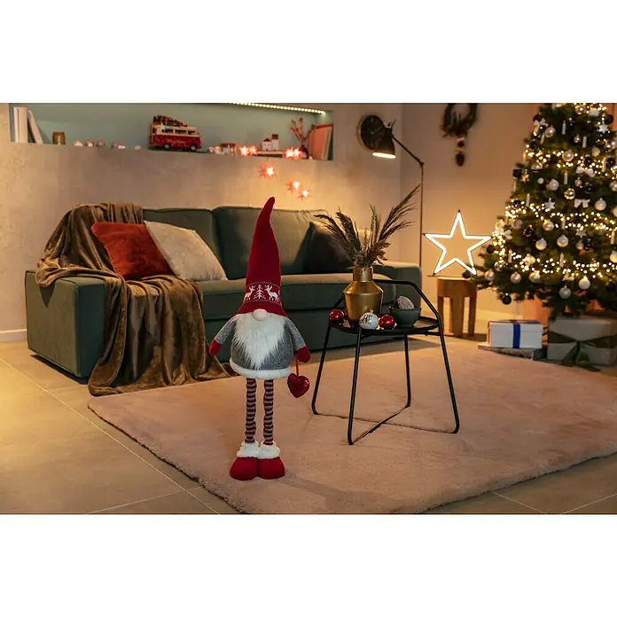 Fellteppich Happy - Rosa, 230 x 160 cm, 100 % Polyester (Flor) - Gemütliches Wohnzimmer mit einem festlichen Zwerg mit Herz, einem grünen Sofa, einem beleuchteten Weihnachtsbaum und weihnachtlicher Deko.