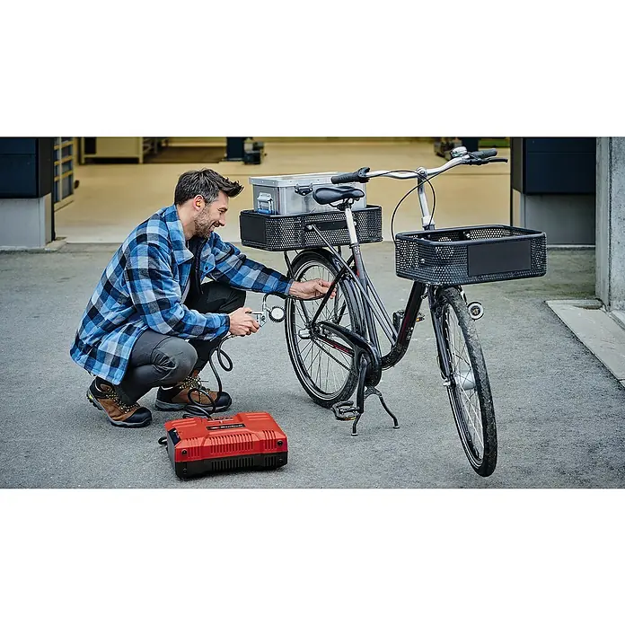 Einhell Power X-Change 18V Schleif- & Gravurwerkzeug TE-MT 18/34 Li-Solo - Ohne Akku, 5.000 U/min - 34.000 U/min - Ein Mann befüllt mit einer roten Einhell Akku-Luftpumpe den Reifen eines Fahrrads, das mit Körben und einer Aluminiumkiste ausgestattet ist.