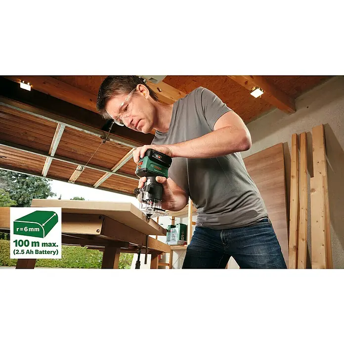 Bosch Power for All 18V Akku-Kantenfräser AdvancedTrimRouter 18V-8 Set - Ohne Akku, Leerlaufdrehzahl: 10.000 U/min - 30.000 U/min - Ein Mann benutzt eine Bosch Akku-Oberfräse, um ein Holzbrett zu bearbeiten. Werkzeuge und Holz sind im Hintergrund sichtbar.