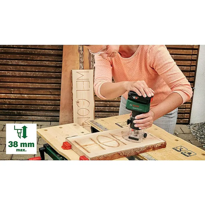 Bosch Power for All 18V Akku-Kantenfräser AdvancedTrimRouter 18V-8 Set - Ohne Akku, Leerlaufdrehzahl: 10.000 U/min - 30.000 U/min - Frau beim Gravieren eines Holzschilds mit dem Bosch Advanced TrimRouter 18V-8. Präzises und kabelloses Arbeiten garantiert.