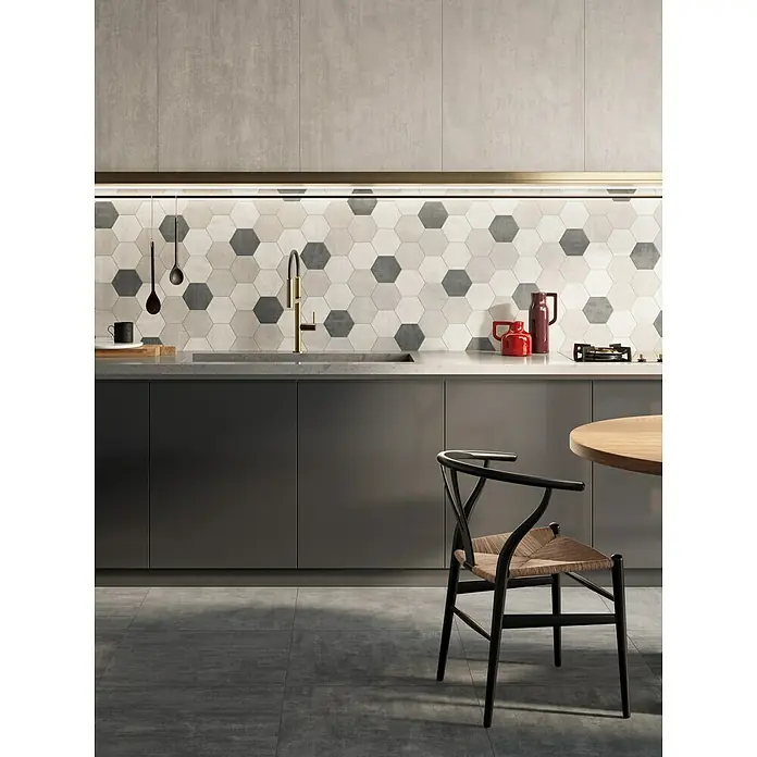 Atlas Concorde Solution Yorkshire Mosaikfliese Hexagon Cold - 25,3 x 33 cm, Beige/Grau/Anthrazit, Matt - Küchenszene mit stilvollen grauen Schränken, sechseckigen Fliesen und einem eleganten Holzstuhl. Moderner Look für Ihr Zuhause.