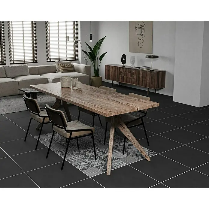 Ambiente by Palazzo Feinsteinzeugfliese Vintage60 x 60 cm, Schwarz, Matt - Elegantes Interieur mit einem markanten Holzesstisch im Fokus, umgeben von stilvollen Stühlen und akzentuiert durch ein dekoratives Teppichmuster.