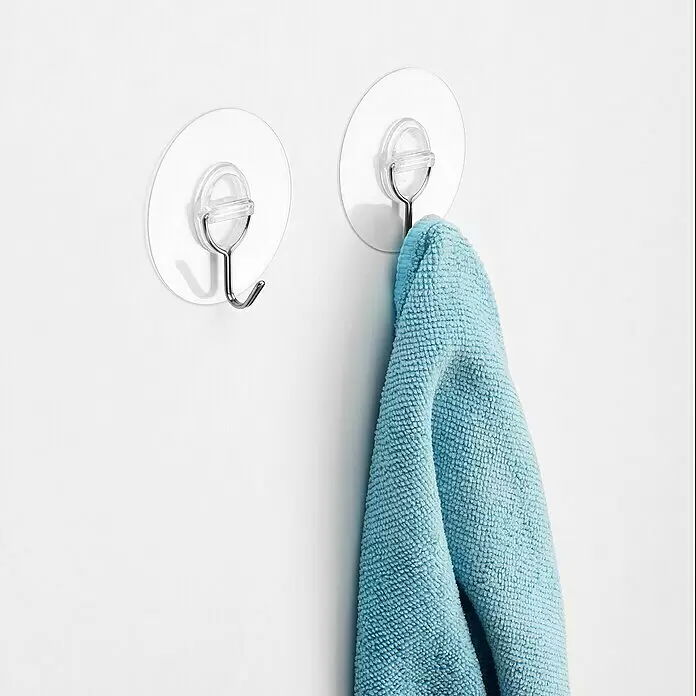 Inofix Gancho para colgar 1292 - Diámetro: 65 mm, Plata - Dos ganchos de ventosa transparentes, uno sosteniendo una toalla de microfibra azul doblada.