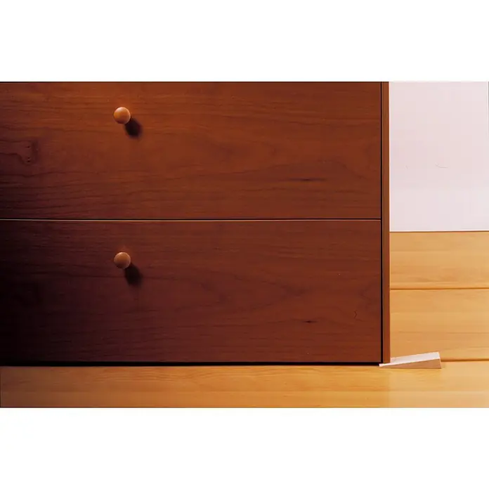 Inofix Cuña para muebles - Transparente, 3 ud. - Cómoda de madera con dos cajones y pomos redondos en el dormitorio, sujeta por una cuña en el suelo de madera.