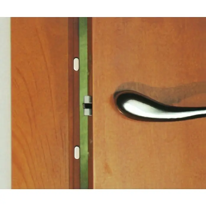 Inofix Almohadilla adhesiva 4060 - 18 ud., Beige - Detalle de una puerta de madera con una elegante manija cromada, que añade un toque de modernidad al diseño clásico.