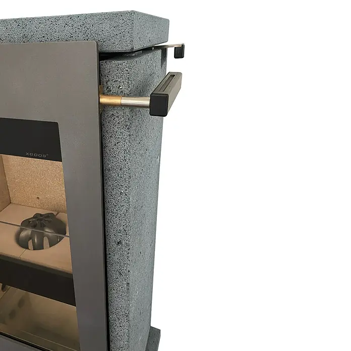 xeoos Kaminofen Patagonia X5 - 5 kW, Raumheizvermögen: 20 m³ - 70 m³, Farbe Verkleidung: Lava - Nahaufnahme eines modernen Kaminofens mit grauer Verkleidung und stilvollen Griffen, die ein gemütliches Ambiente versprechen.