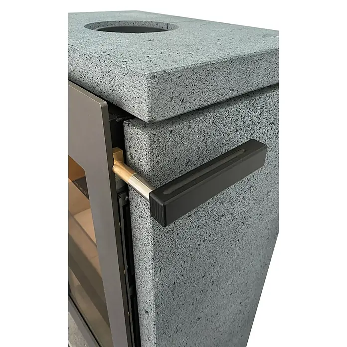 xeoos Kaminofen Patagonia X5 - 5 kW, Raumheizvermögen: 20 m³ - 70 m³, Farbe Verkleidung: Lava - Nahaufnahme eines modernen Kaminofens mit Betonverkleidung und einem Griff aus Metall und Holz.
