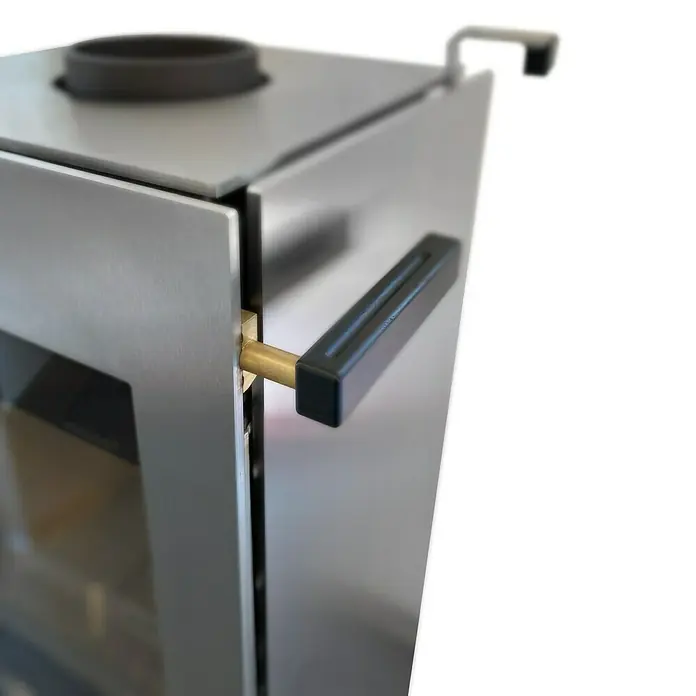 xeoos Kaminofen Patagonia X5 - 5 kW, Raumheizvermögen: 20 m³ - 70 m³, Farbe Verkleidung: Inox Edelstahl - Nahaufnahme eines modernen Holzofens mit silberner Oberfläche und schwarzem Griff, der ein elegantes Design und hochwertige Verarbeitung zeigt.