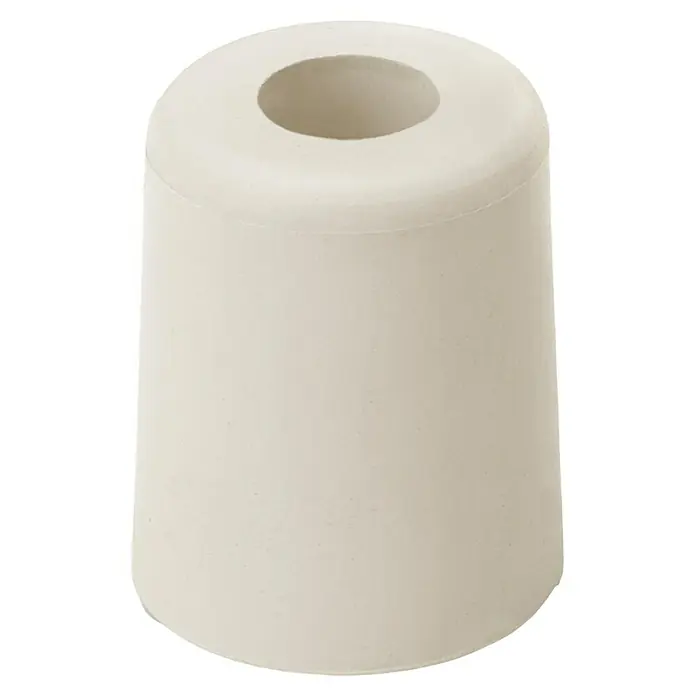 Inofix Tope de puerta 3048 - Caucho macizo, Marfil - Primer plano de un tope de puerta de goma cilíndrico de color claro con un agujero en el centro, sobre un fondo oscuro.