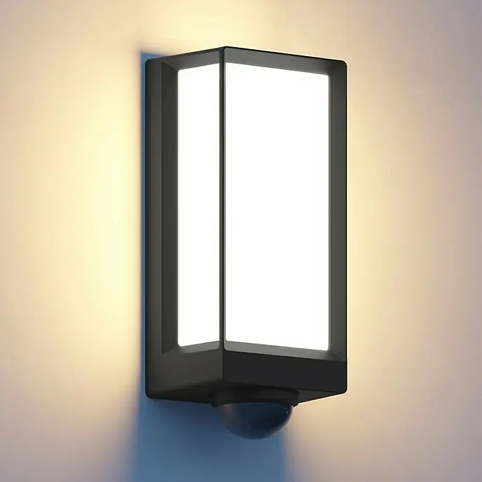 Steinel LED-Außenwandleuchte L 42 SC ANT - 12,6 W, 10,5 x 13,1 x 30,6 cm, Anthrazit, IP54 - Nahaufnahme einer modernen, rechteckigen Außenwandleuchte mit Bewegungsmelder, die ein helles, weißes Licht ausstrahlt und an einer Wand befestigt ist.