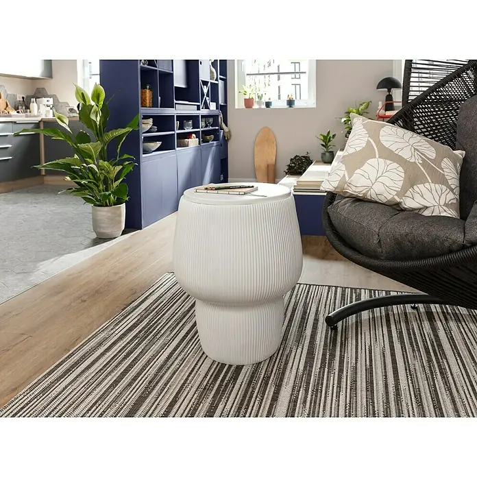 Eglo Tischleuchte ARANZOLA - 40 W, Schwarz/Weiß, E27 - Das Bild zeigt einen weißen, runden Beistelltisch mit gerippter Oberfläche auf einem gestreiften Teppich in einem hellen Wohnraum.