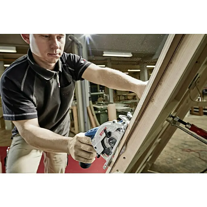 Bosch Professional Akku-Handkreissäge GKS 12V-26 - 12 V, Li-Ionen, Ohne Akku, Sägeblatt: 85 mm, 1.400 U/min - Ein Handwerker benutzt eine Bosch Kreissäge, um Holz zu sägen. Das Werkzeug ist ideal für präzise Schnitte in verschiedenen Materialien.