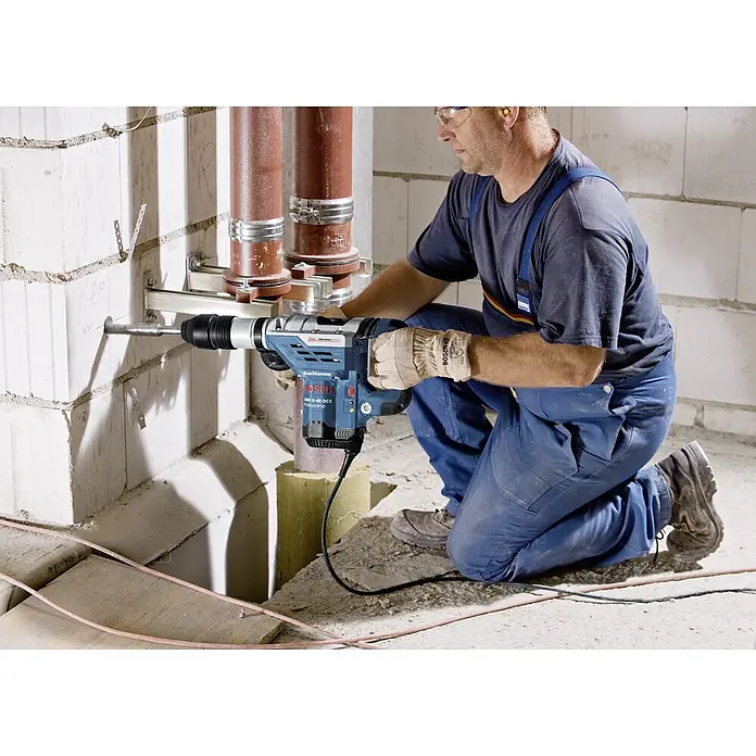 Bosch Professional Martillo perforador GBH 5-40 DCE - 1.150 W, 8,8 J, Alojamiento SDS-MAX - Un artesano está perforando una pared con un Boschhammer GBH 8-45 DCE Professional.