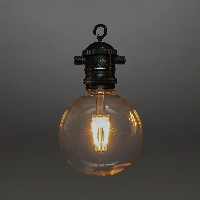 Konstsmide LED-Lichterkette - Außen, 4,5 cm, Bernstein, Rund, Solarbetrieben - Nahaufnahme einer hängenden Edison-Glühbirne mit warmem Licht, die eine Vintage-Ästhetik und dekorative Beleuchtung betont.