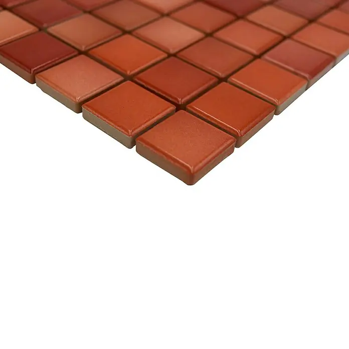 Mosaikfliese JAB 23F218 mix red - 29,7 x 29,7 cm, Mix Brick Rot, Glänzend - Nahaufnahme von kleinen, quadratischen Mosaikfliesen in verschiedenen Rottönen auf einem schwarzen Untergrund.