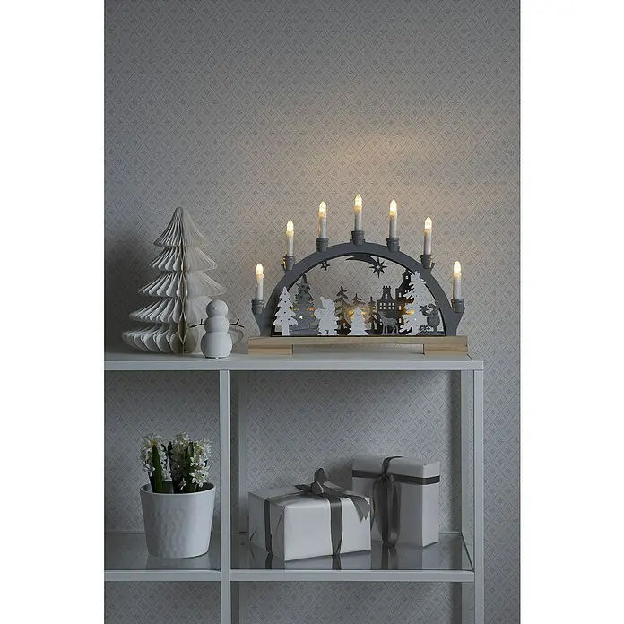 Konstsmide LED-Holzsilhouette Wanderer im Wald - 45 x 5 x 33 cm, Weiß, Grau, Batteriebetrieben, Warmweiß, 0,6 W - Weihnachtliche Dekoration mit Lichterbogen, Papierbaum, Schneemann, Hyazinthen und verpackten Geschenken auf einem weißen Regal.