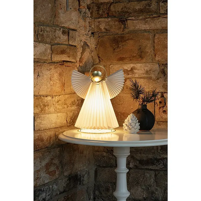 Konstsmide LED-Weihnachtsdekoleuchte Papierengel - 21 x 15 x 26 cm, Weiß, Netzbetrieben - Stimmungsvolle Aufnahme einer Engel-Tischleuchte mit plissiertem Schirm, die warmes Licht spendet und eine festliche Atmosphäre erzeugt.