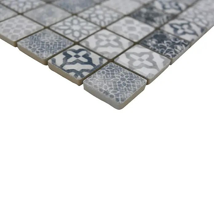 Mosaikfliese JAB 23PV02 grey - 29,7 x 29,7 cm, Grau, Matt - Nahaufnahme eines Musters von quadratischen Fliesen in Grau- und Weißtönen mit verschiedenen dekorativen Designs auf schwarzem Hintergrund.