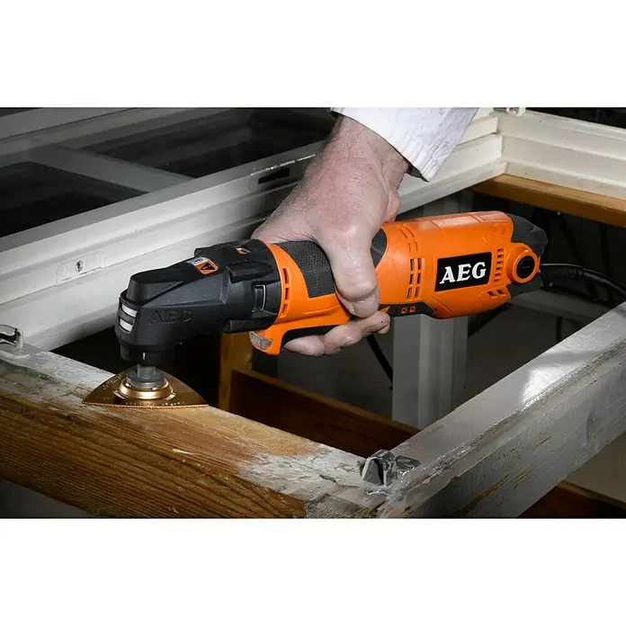 AEG Powertools Elektro-Multifunktionswerkzeug OMNI 300 - 300 W, Sonstige - Ein AEG Multifunktionswerkzeug wird verwendet, um ein Holzstück zu bearbeiten. Das Werkzeug ist orange und schwarz.