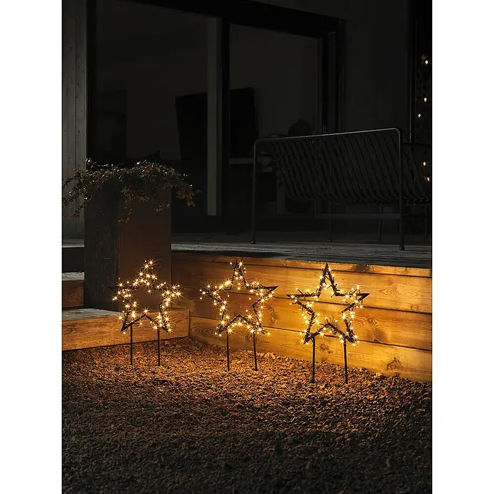 Konstsmide LED-Gartenstecker Stern 3er-Set - Schwarz, Bernstein, Außen, 3 Stk. - Drei dekorative Sternleuchten im Garten, die eine warme und festliche Atmosphäre schaffen. Die Sterne sind mit kleinen Lichtern geschmückt.