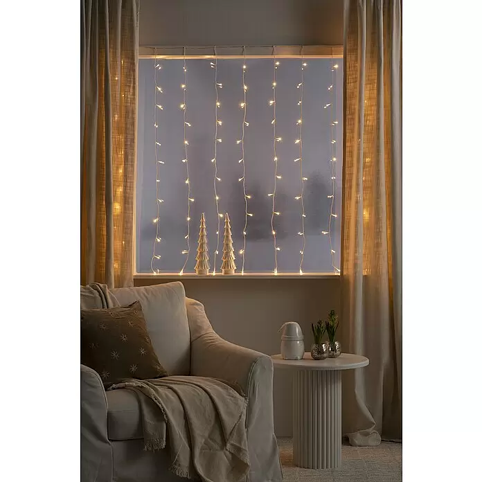 Konstsmide LED-Lichtervorhang - Innen, 140 cm, Bernstein, 120 Stk., Netzbetrieben - Warmweiße LED-Lichterkette hängt vertikal in einem Fenster und schafft eine gemütliche, festliche Atmosphäre.