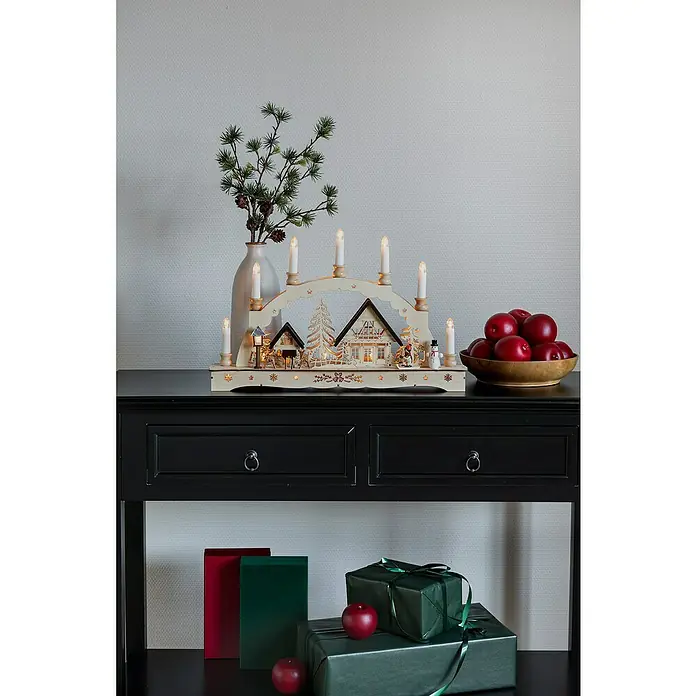 Konstsmide LED-Lichterbogen - Batteriebetrieben, L x B x H: 48 x 8 x 30 cm, Warmweiß, Naturfarben - Weihnachtliche Szene mit einem traditionellen hölzernen Lichterbogen, Dekorationen und Geschenken auf einem schwarzen Konsolentisch.