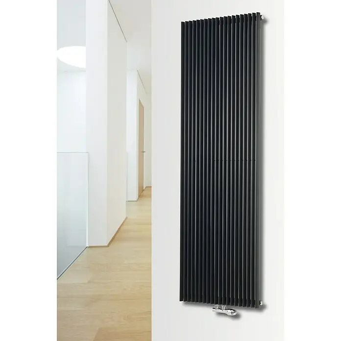 Ximax Raumheizkörper Triton - B x H: 450 x 1.800 mm, Wärmeleistung bei Vorlauftemperatur von 75 °C (D: 50): 1.080 W, Anthrazit - Ein moderner, vertikaler Heizkörper in Schwarz, der an einer weißen Wand in einem minimalistischen Flur hängt. Stilvolles Heizsystem.