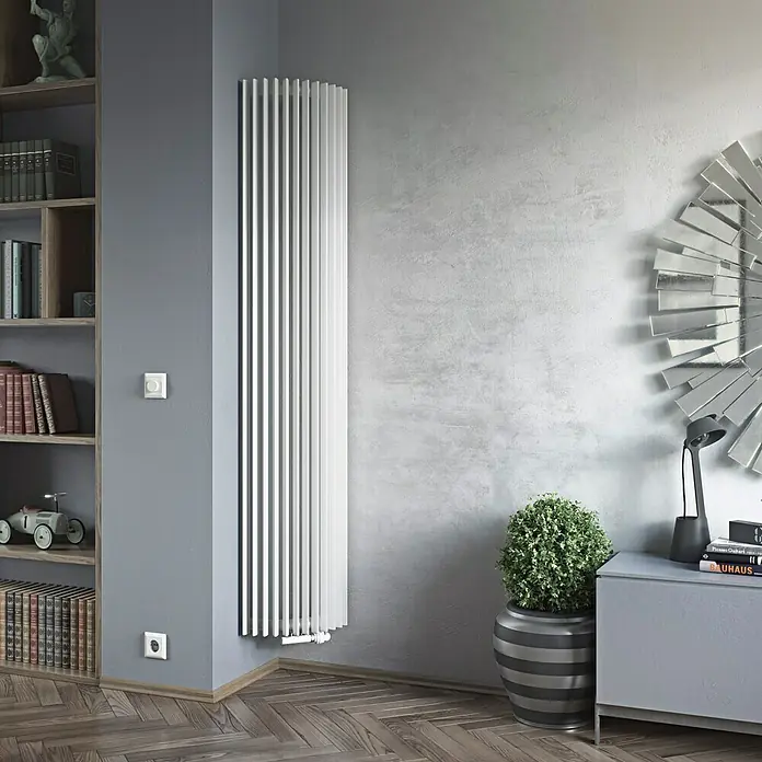Ximax Raumheizkörper Triton-E - B x H: 340 x 1.800 mm, Wärmeleistung bei Vorlauftemperatur von 75 °C (D: 50): 850 W - Das Bild zeigt einen modernen, weißen Heizkörper an einer grauen Wand, der das stilvolle Interieur eines Zimmers ergänzt.