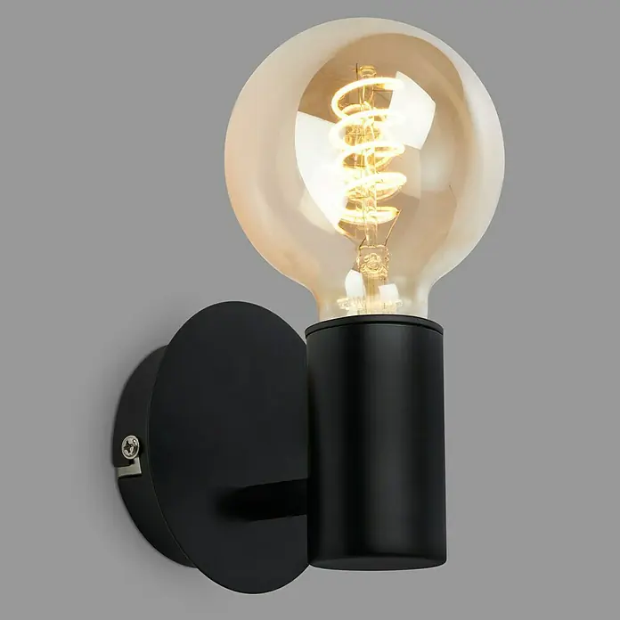 Briloner Wandleuchte KOSOL - 10 W, Schwarz, E27 - Nahaufnahme einer Wandleuchte mit einer runden Glühbirne, die ein warmes Licht ausstrahlt, montiert auf einer schwarzen, zylindrischen Basis.