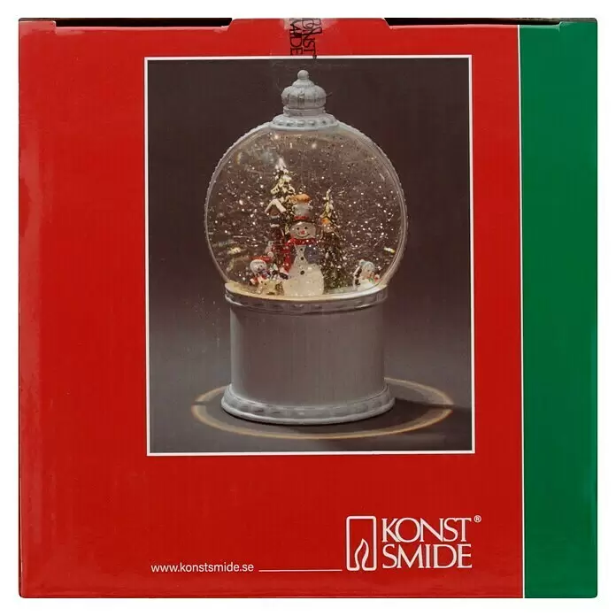 Konstsmide LED-Schneelaterne Schneemann mit Baum - Innen, Altweiß, 12,5 x 12,5 x 21 cm, Schneemann mit Christbaum, Batteriebetrieben - Eine Schneekugel mit Schneemann, kleinen Schneemännern, Bäumen und einem Vogel auf silbernem Sockel. Glitzernder Schnee fällt darin.