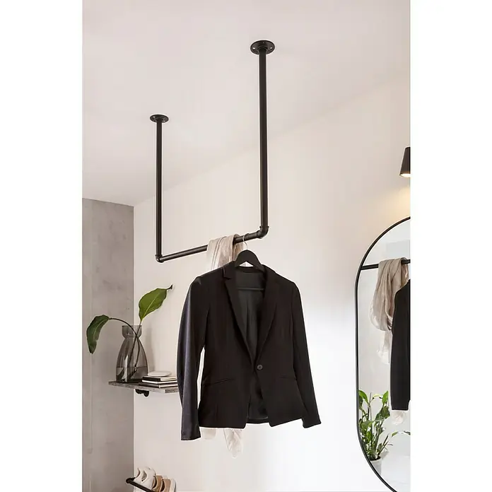 Walteco Rusticline Universalschraube RT-50Ø x L: 5 x 16 mm, Schwarz, 16 Stk. - Eine moderne Garderobenstange aus dunklem Metall mit einer schwarzen Jacke daran. Zeitgemäße Flurmöbel für eine minimalistische Einrichtung.