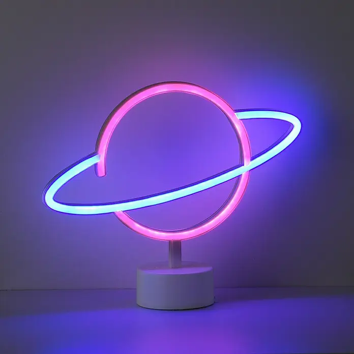 Just Light LED-Dekoleuchte Neon Saturn - Neon Saturn, L x B x H: 8,5 x 29,5 x 24 cm, Netzbetrieben - Dekoratives Neonlicht in Form eines Planeten mit rosa und blauen Akzenten, platziert auf einem weißen Sockel für eine spielerische Atmosphäre.