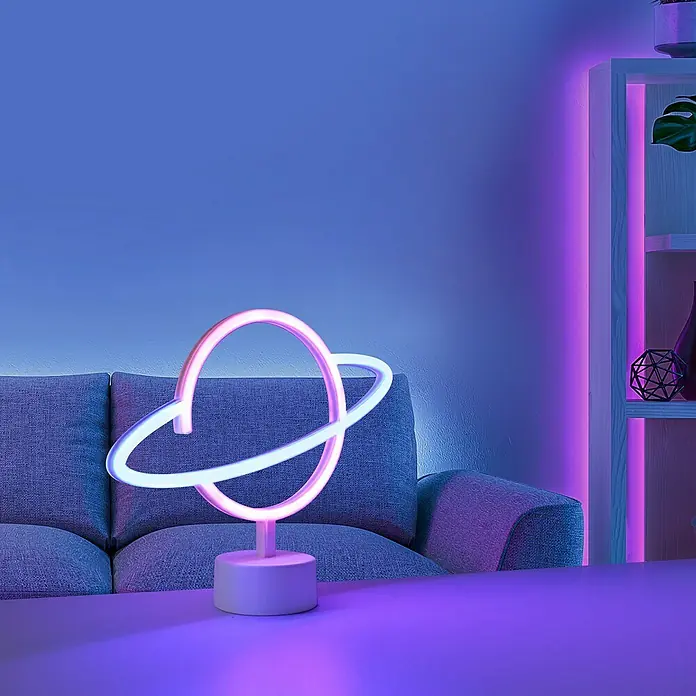 Just Light LED-Dekoleuchte Neon Saturn - Neon Saturn, L x B x H: 8,5 x 29,5 x 24 cm, Netzbetrieben - Das Bild zeigt eine stylische LED-Tischleuchte in Form eines Planeten mit Ring, perfekt als Deko-Element im modernen Wohnraum.