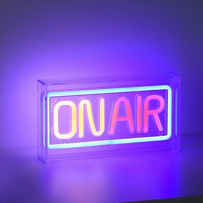 Just Light LED-Dekoleuchte Neon On Air - Neon On Air, L x B x H: 8,5 x 29,5 x 24 cm, Netzbetrieben - Nahaufnahme eines leuchtenden "On Air"-Schildes mit Neonbuchstaben in einem durchsichtigen Gehäuse, das eine lebendige Atmosphäre schafft.