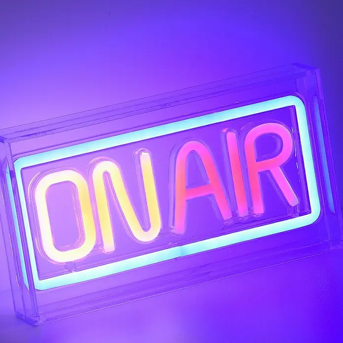 Just Light LED-Dekoleuchte Neon On AirNeon On Air, L x B x H: 8,5 x 29,5 x 24 cm, Netzbetrieben - Nahaufnahme einer leuchtenden "On Air"-Schildbox, die in lebendigen Gelb-, Rosa- und Blautönen erstrahlt und die Aufnahmebereitschaft signalisiert.