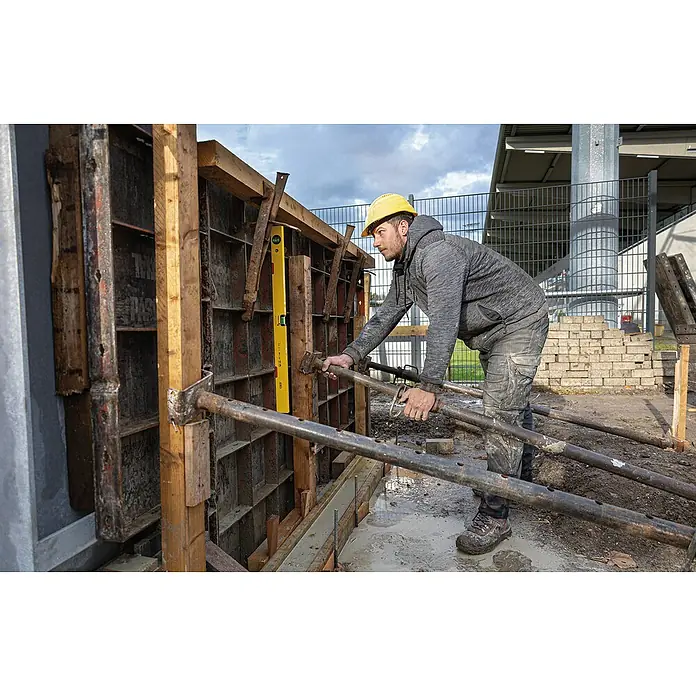 Stabila Wasserwaage Type 70 M - Länge: 40 cm, Anzahl Libellen: 2 Stk. - Ein Bauarbeiter justiert mit einer Wasserwaage und robusten Baustützen eine Betonschalung auf einer Baustelle. Präzision für stabile Strukturen.