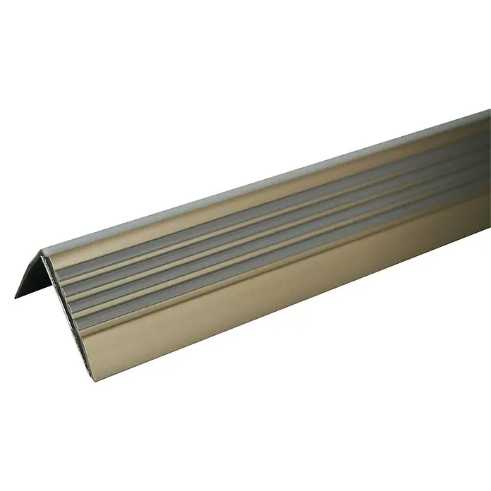 Döllken Treppenkantenprofil - 125 cm x 40 mm x 40 mm, Champagner - Nahaufnahme eines goldenen Treppenkantenprofils mit Rillen auf schwarzem Hintergrund.