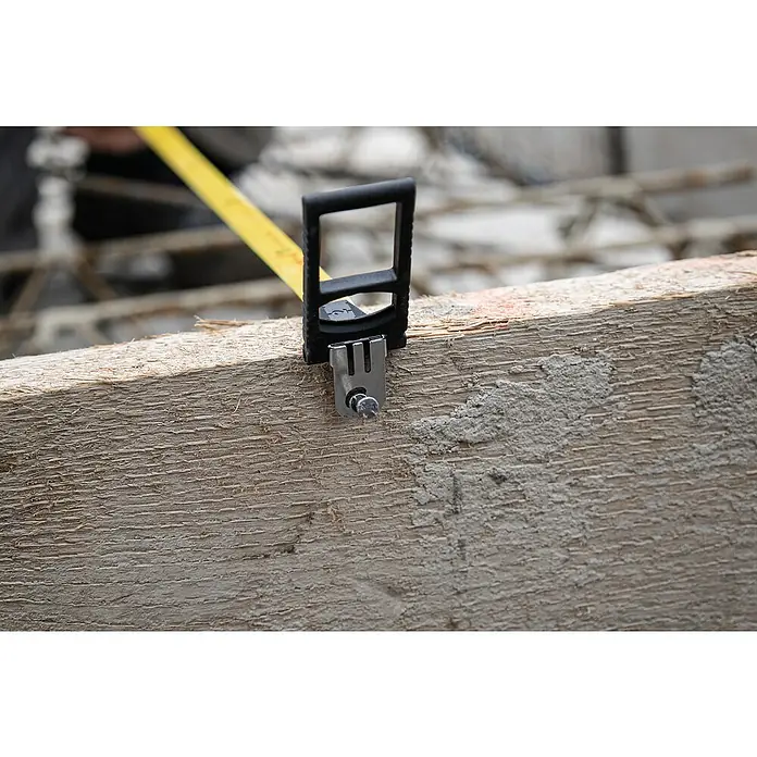Stabila Rahmenmaßband 50 m - 50 m, Genauigkeitsklasse: II, Material: Stahlband - Nahaufnahme eines Bandmaßes mit Clip an einem Holzstück befestigt, ideal für präzise Messungen und Bauprojekte.