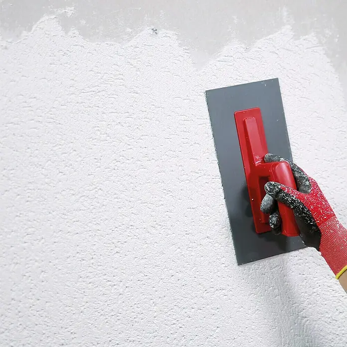 SG Weber Münchner-Rauhputz - Körnung: 3 mm, 25 kg - Glättekelle mit rotem Griff und grauer Klinge wird zum Auftragen von Putz auf eine Wand mit Textur verwendet.