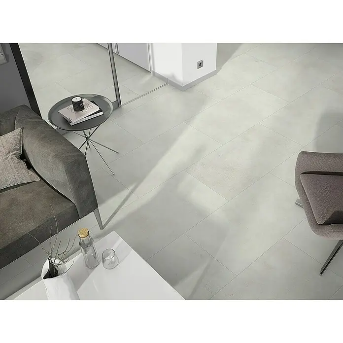 Classen Designboden Pro Nature - Milford, Fliese, 638 x 310 x 4 mm - Ein modernes Wohnzimmer mit einem grauen Sofa, einem Couchtisch und einem Sessel, die auf einem stilvollen, hellgrauen Fliesenboden stehen.