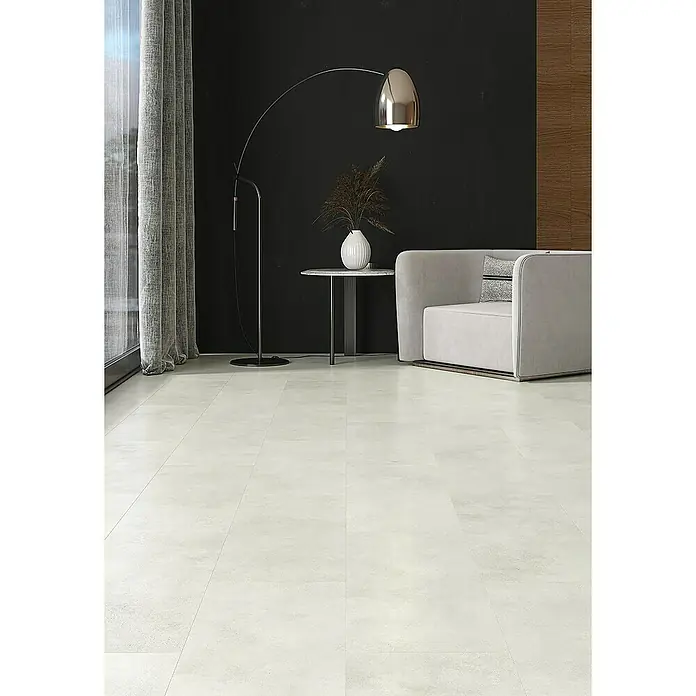 Classen Designboden Pro Nature - Milford, Fliese, 638 x 310 x 4 mm - Helles, modernes Wohnzimmer mit beigem Sessel, Stehlampe und einem eleganten, weißen Couchtisch mit Blumenvase auf hellen Bodenfliesen.