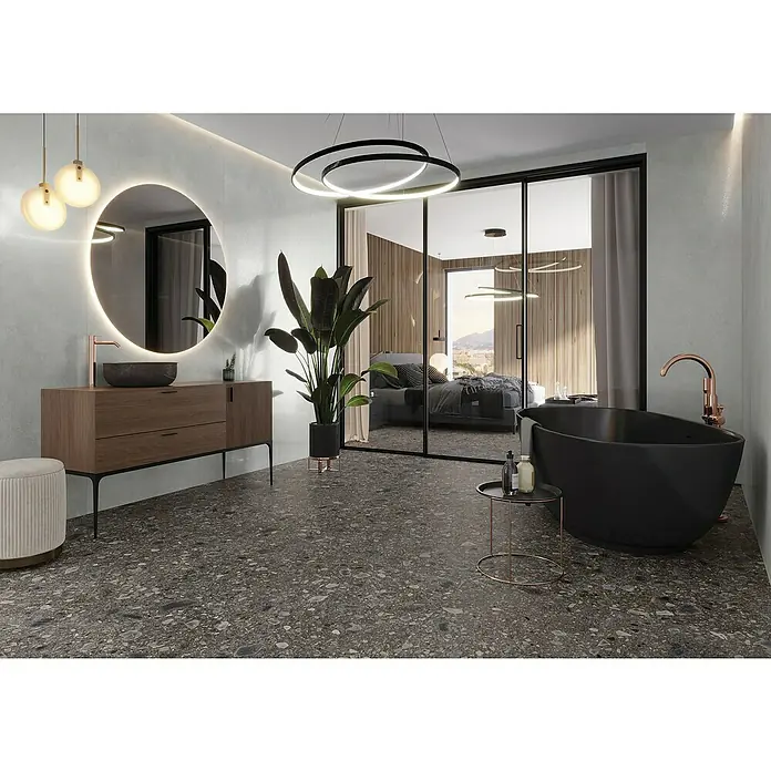 Feinsteinzeugfliese Terrazzo Ceppo - 119,7 x 119,7 cm, Schwarz, Glänzend - Elegantes Badezimmer-Interieur mit Waschtisch, Spiegel, Badewanne und moderner Beleuchtung für ein stilvolles Ambiente.