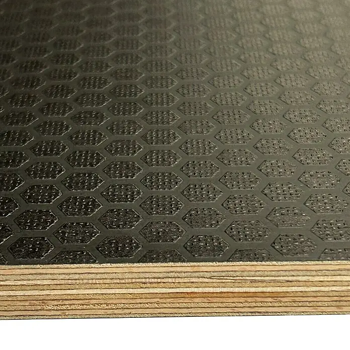 Siebdruckplatte Fixmaß HexaBirke, 1.200 x 600 x 9 mm - Nahaufnahme von Hexagon-gemustertem Siebdruck-Sperrholz, das seine Schichten und Textur zeigt. Das robuste Material eignet sich gut für Bauprojekte.