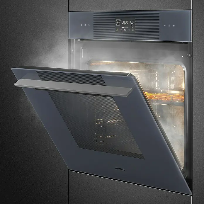 Smeg Horno empotrado SO6102S3PG - Número de tipos de calentamiento: 12 ud., Volumen horno: 67 l - Primer plano de un horno Smeg con la puerta abierta y vapor saliendo. El diseño moderno del horno es el foco principal.