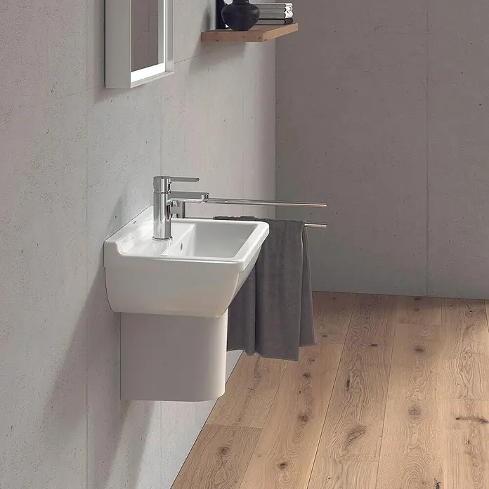 Duravit Starck 3 Waschbecken - 45 x 32 cm, Ohne Spezialglasur, Hahnloch: Mitte, Mit Überlauf, Weiß - Weißes Waschbecken mit Armatur und Handtuchhalter an einer Betonwand. Darüber ein Spiegel und ein Regal mit Deko-Objekten.