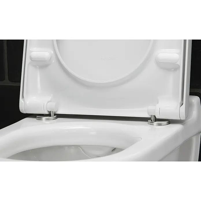 Duravit Starck 3 Wand-WC-Set - Spülrandlos, Mit antibakterieller Glasur, Spülform: Tief, WC Abgang: Waagerecht, Weiß - Nahaufnahme eines weißen Duravit Toilettensitzes mit Chromscharnieren, der auf einer weißen Toilette montiert ist und für Hygiene und Komfort sorgt.